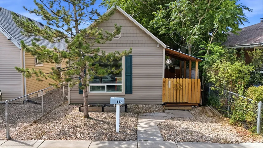 Front exterior with siding and shingle accents, featuring a covered porch with wood railing and a concrete walkway
