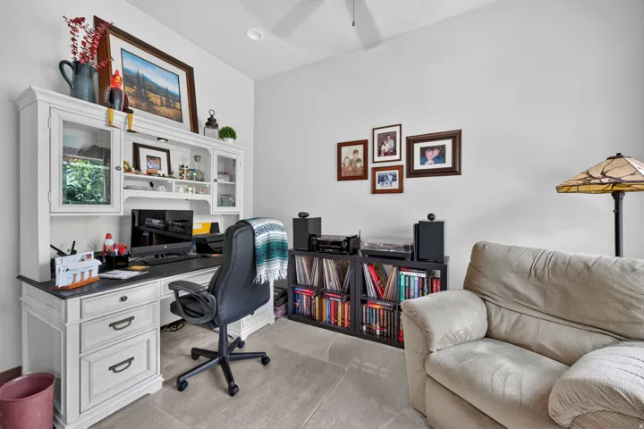 Built-in desk hutch with glass-front cabinetry, neutral wall paint, and recessed ceiling lighting