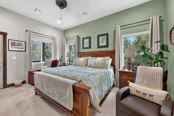 Carpeted bedroom with a ceiling fan, recessed lighting, and dual windows