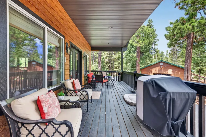 Expansive outdoor deck featuring wood-finish flooring, a covered patio area, and direct exterior access