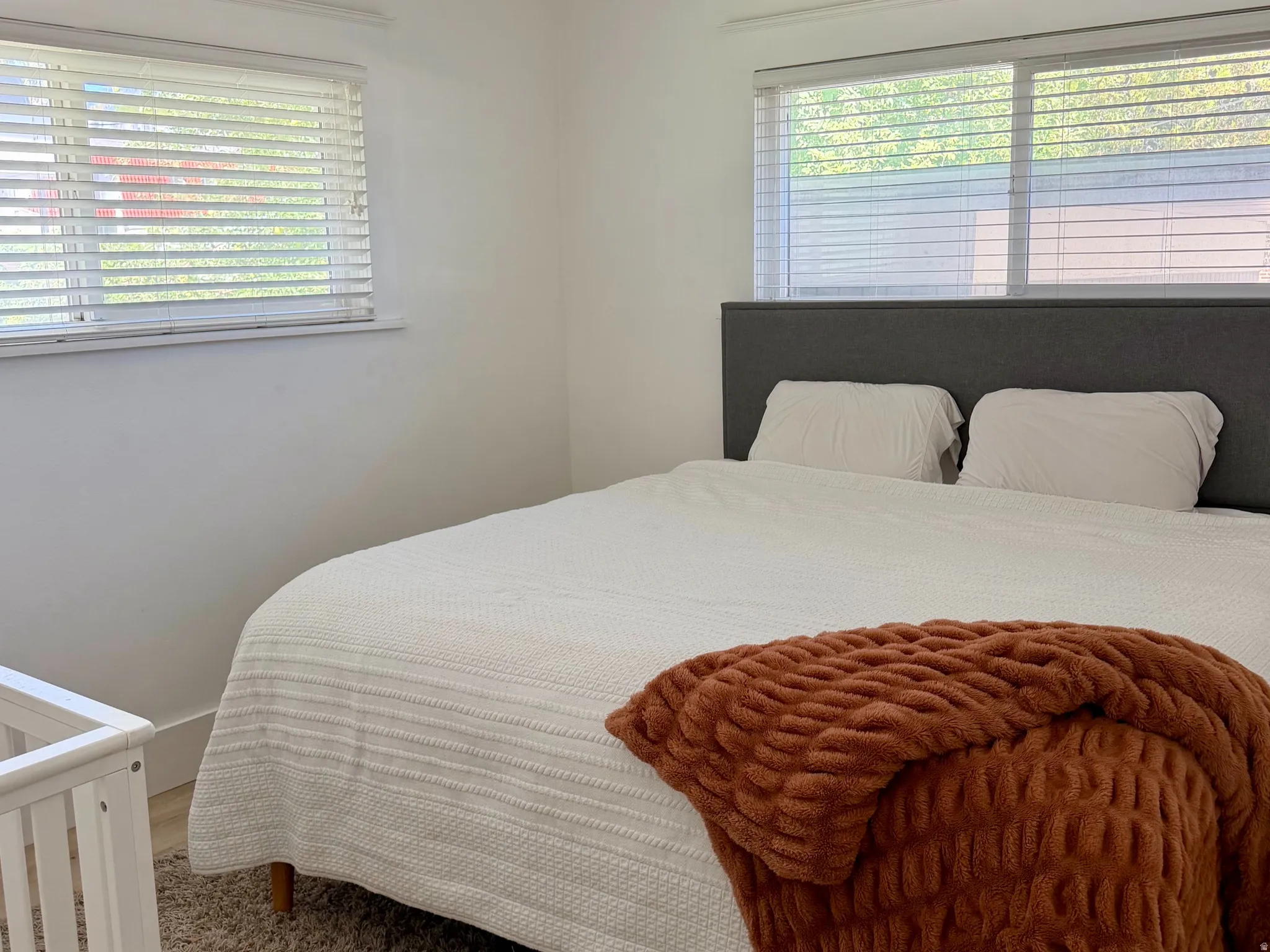 Recessed windows with blinds, wood-finish flooring, and a ceiling fan with integrated lighting