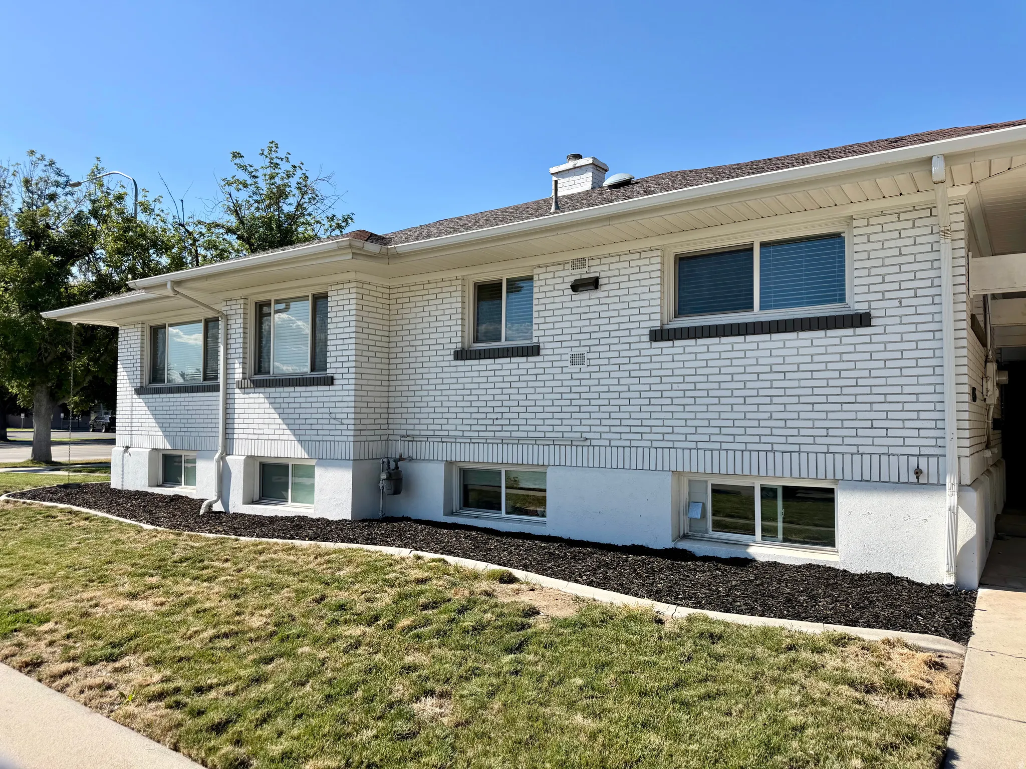 White brick exterior with a contrasting dark brick accent course