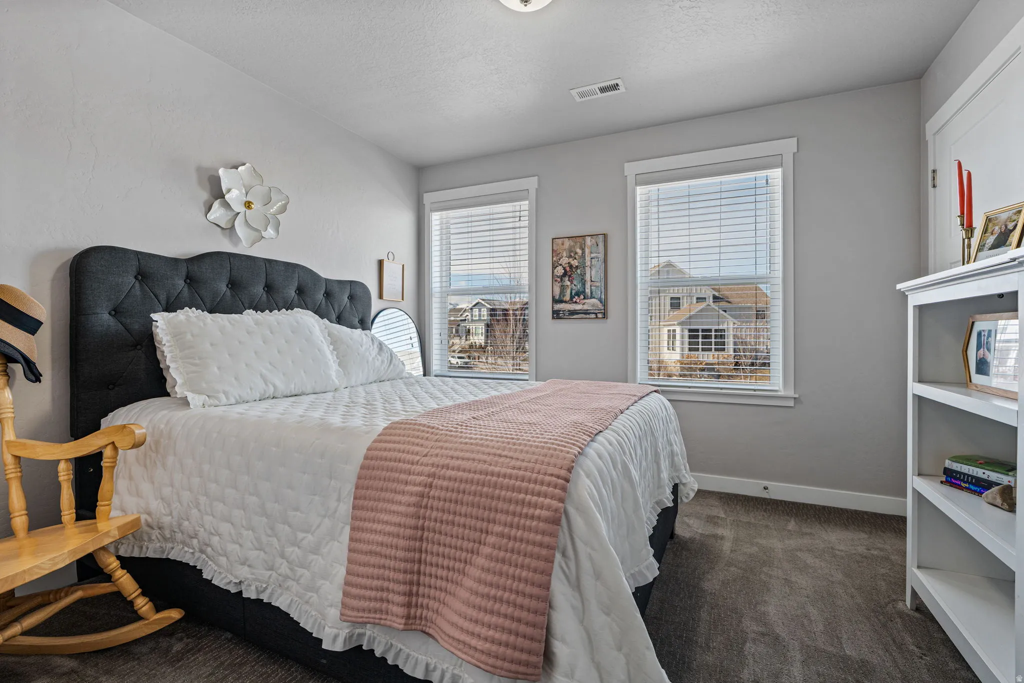 Two windows with white blinds, light gray walls, and dark gray carpeting