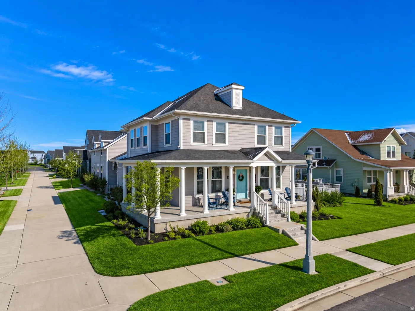 Two-story residence with light gray siding and a dark shingle roof