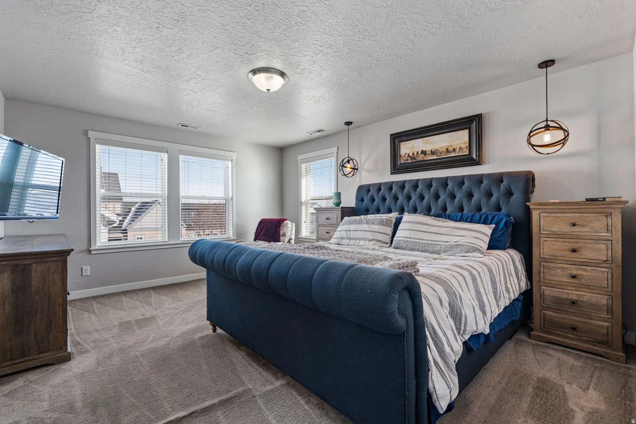 Bright room featuring multiple windows with blinds, recessed lighting, and pendant light fixtures
