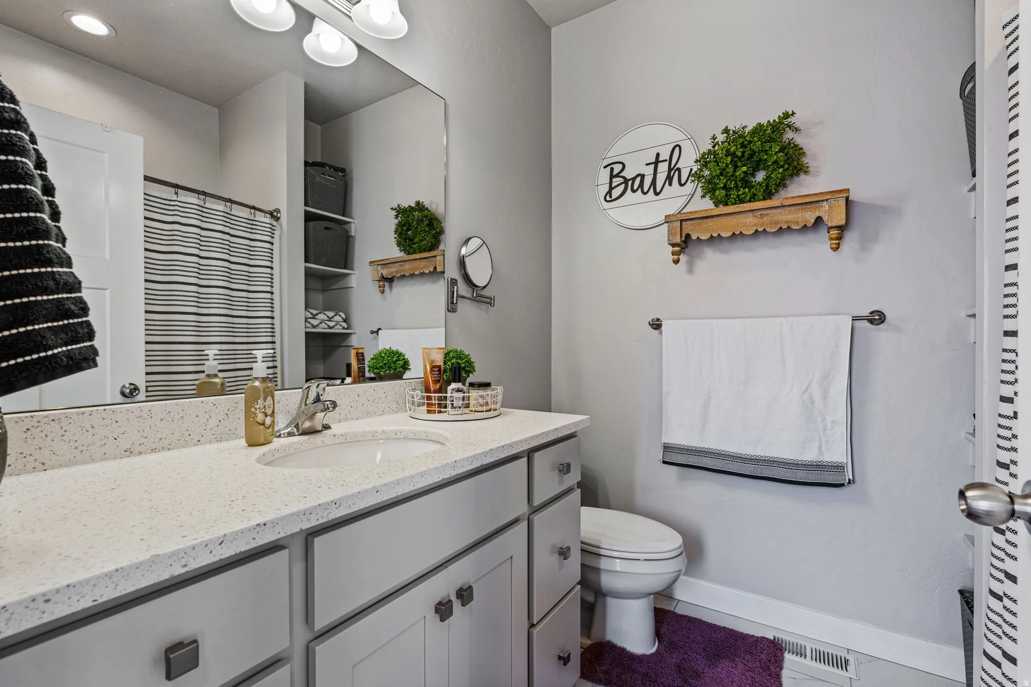 Vanity with an integrated sink, light-toned countertop, and recessed built-in shelving