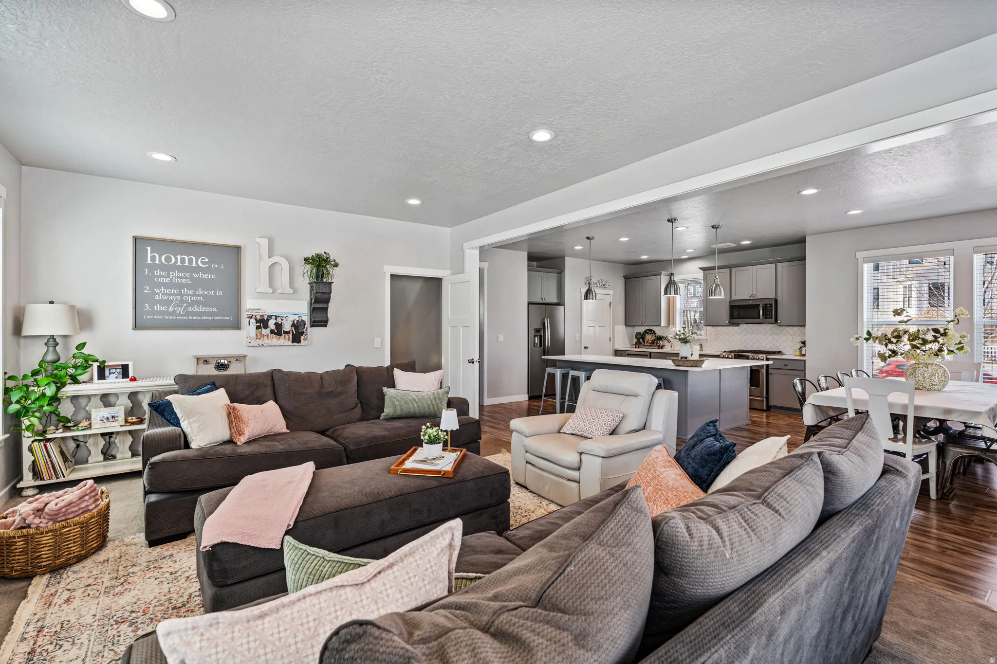 Recessed lighting, wood-finish flooring, gray kitchen cabinetry, kitchen island with seating, and white subway tile backsplash