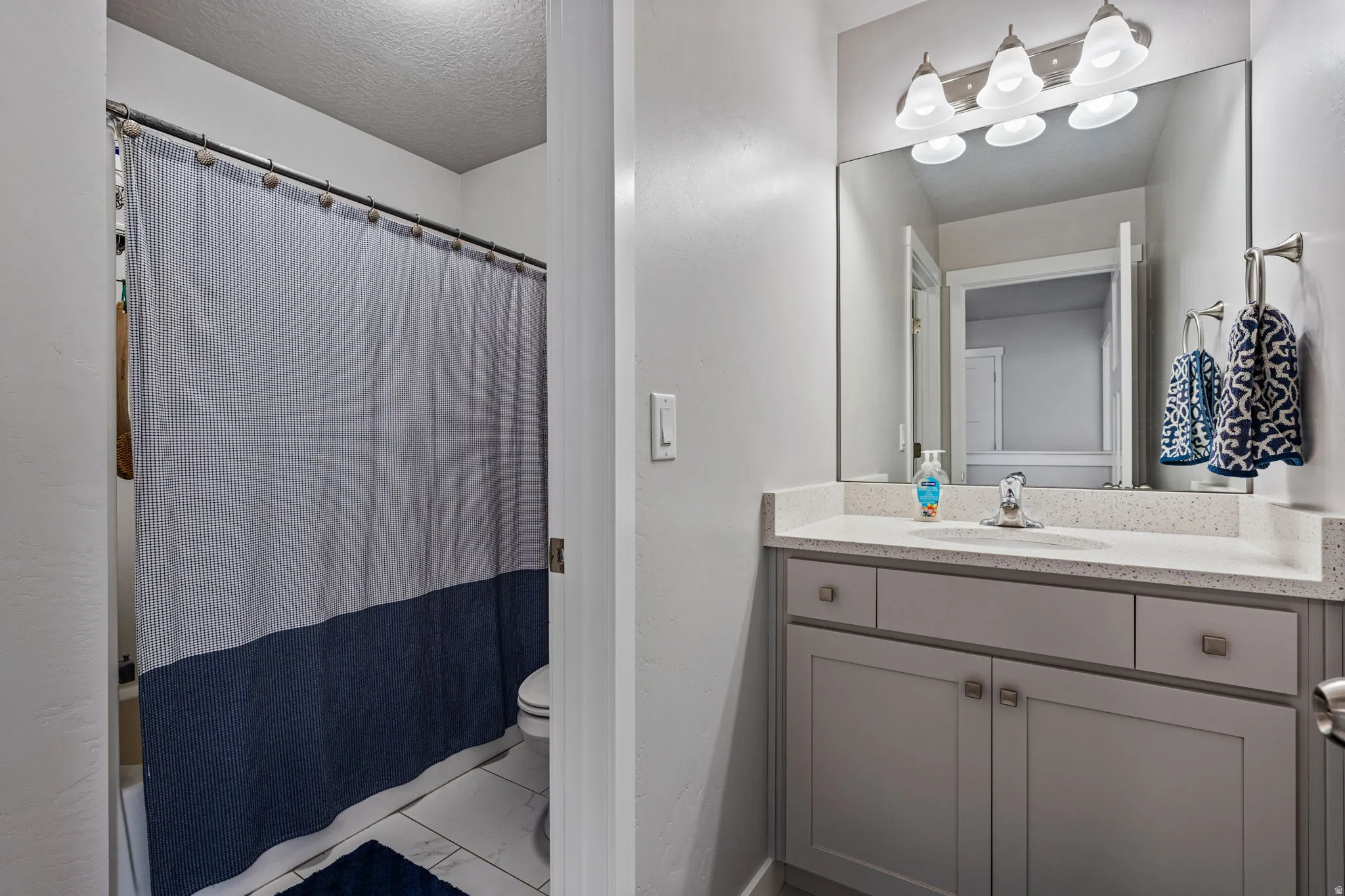 Bathroom featuring a vanity with a light countertop, integrated sink, and brushed nickel faucet