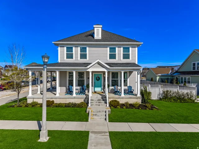 Two-story residence featuring light gray siding, white trim, and a dark shingle roof