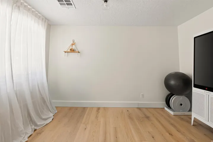 Light wood-finish flooring with white baseboards and light-toned wall paint