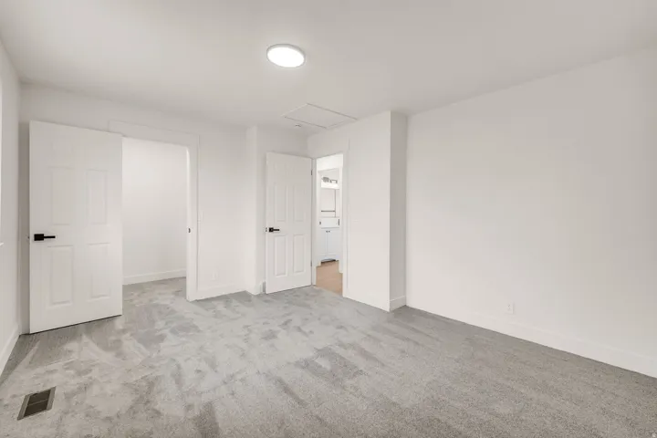 Neutral color palette with light gray carpeting, white walls, and white trim