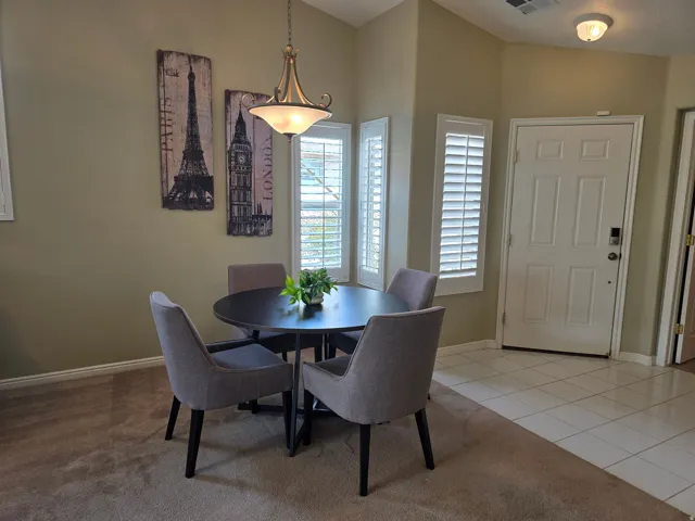Angled walls with a corner window, plantation shutters, and a brass-tone pendant light fixture