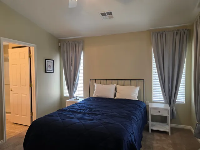 Neutral wall paint, carpeting, white window blinds, and a paneled door