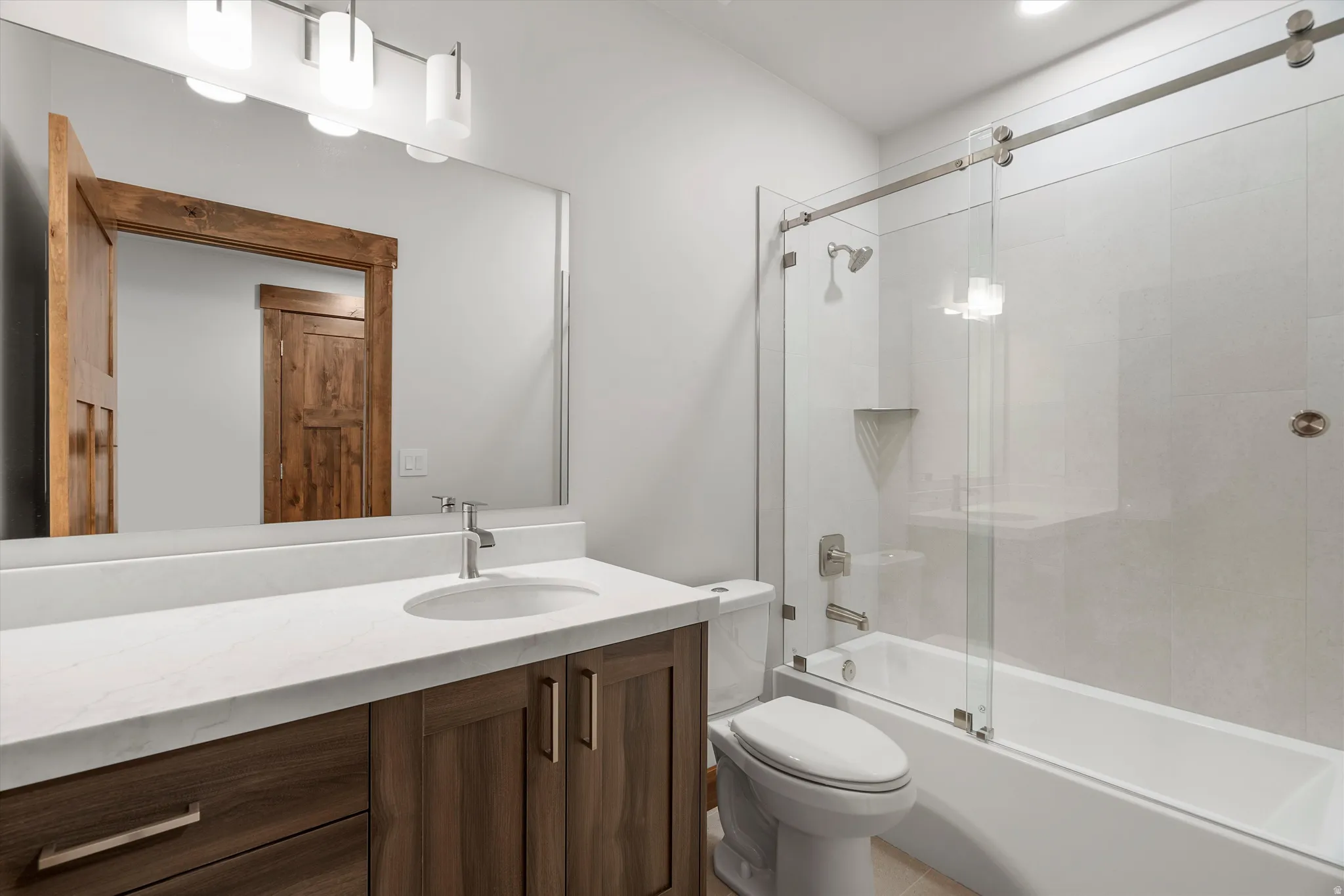 Bathroom vanity with a white countertop and wood-finish cabinetry