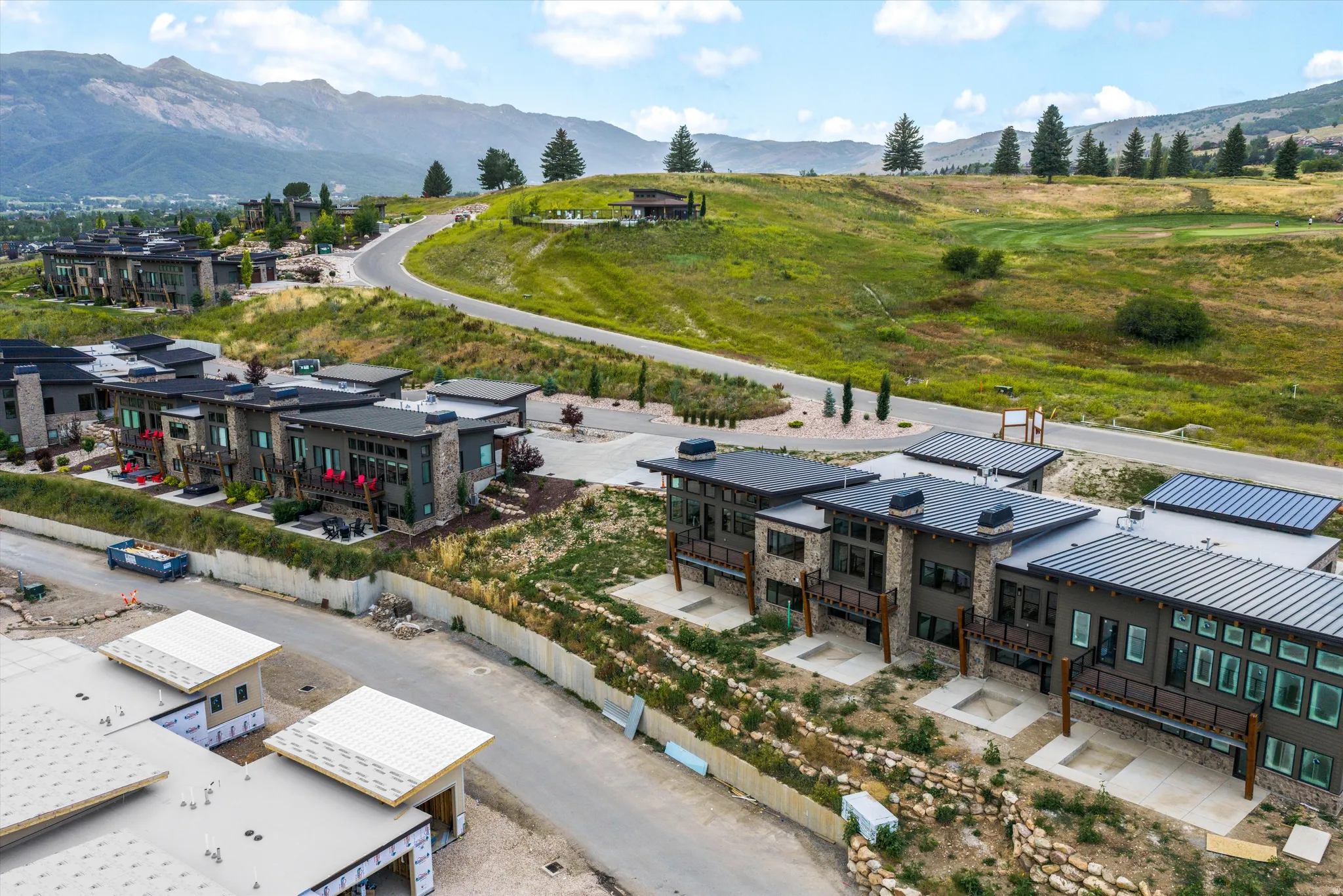 Modern architectural design with flat roofs, stone and panel siding, and balconies