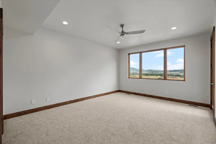 Expansive window offering a scenic landscape, wood-finish window frames, recessed ceiling lighting, and a ceiling fan