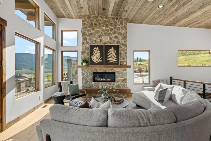 Soaring vaulted wood-finish ceiling with expansive multi-pane windows framing mountain vistas