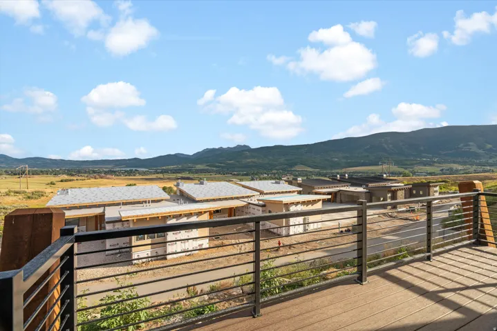Expansive outdoor deck with composite decking and cable railing, offering a wide landscape with distant mountains