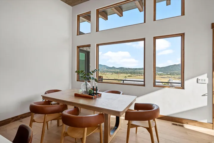 Expansive windows with wood trim, wood-finish flooring, and high ceilings