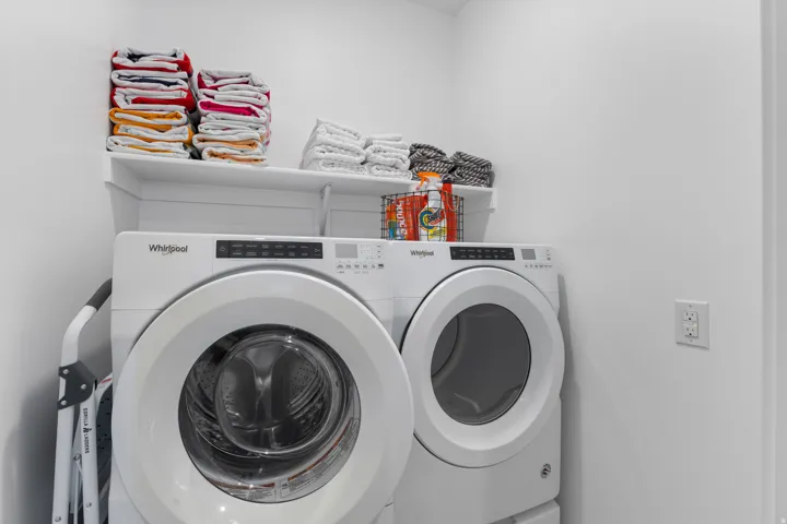 Built-in wall shelving with modern front-load washer and dryer