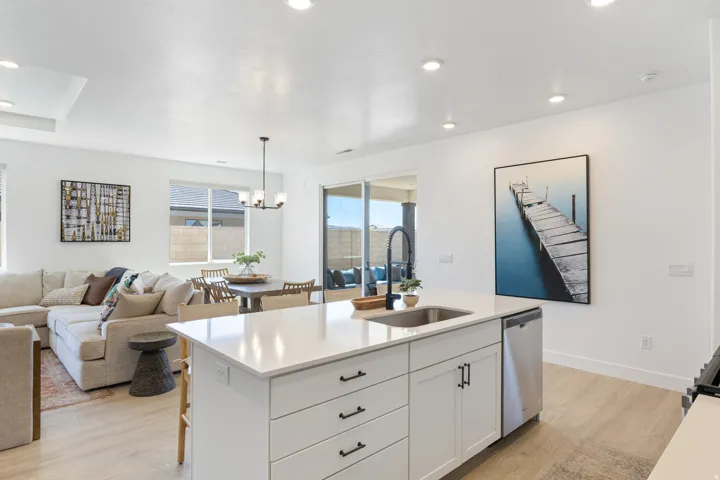 Modern kitchen island featuring a stainless steel sink, matte black faucet, and integrated dishwasher