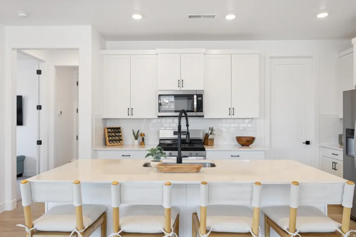 Kitchen featuring a central island, white shaker cabinetry, stainless steel appliances, and a subway tile backsplash