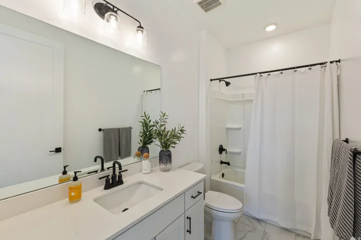 Vanity with an integrated rectangular sink, matte black faucet, and white countertop