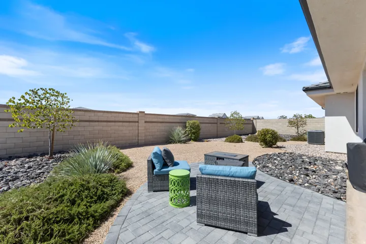 Paver patio with a gravel and rock landscape, complemented by a block perimeter wall