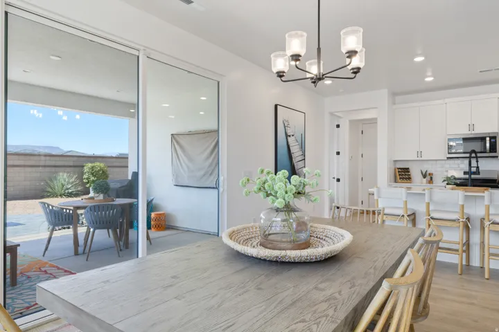 Dining area with wood-finish flooring, a contemporary chandelier, and recessed lighting