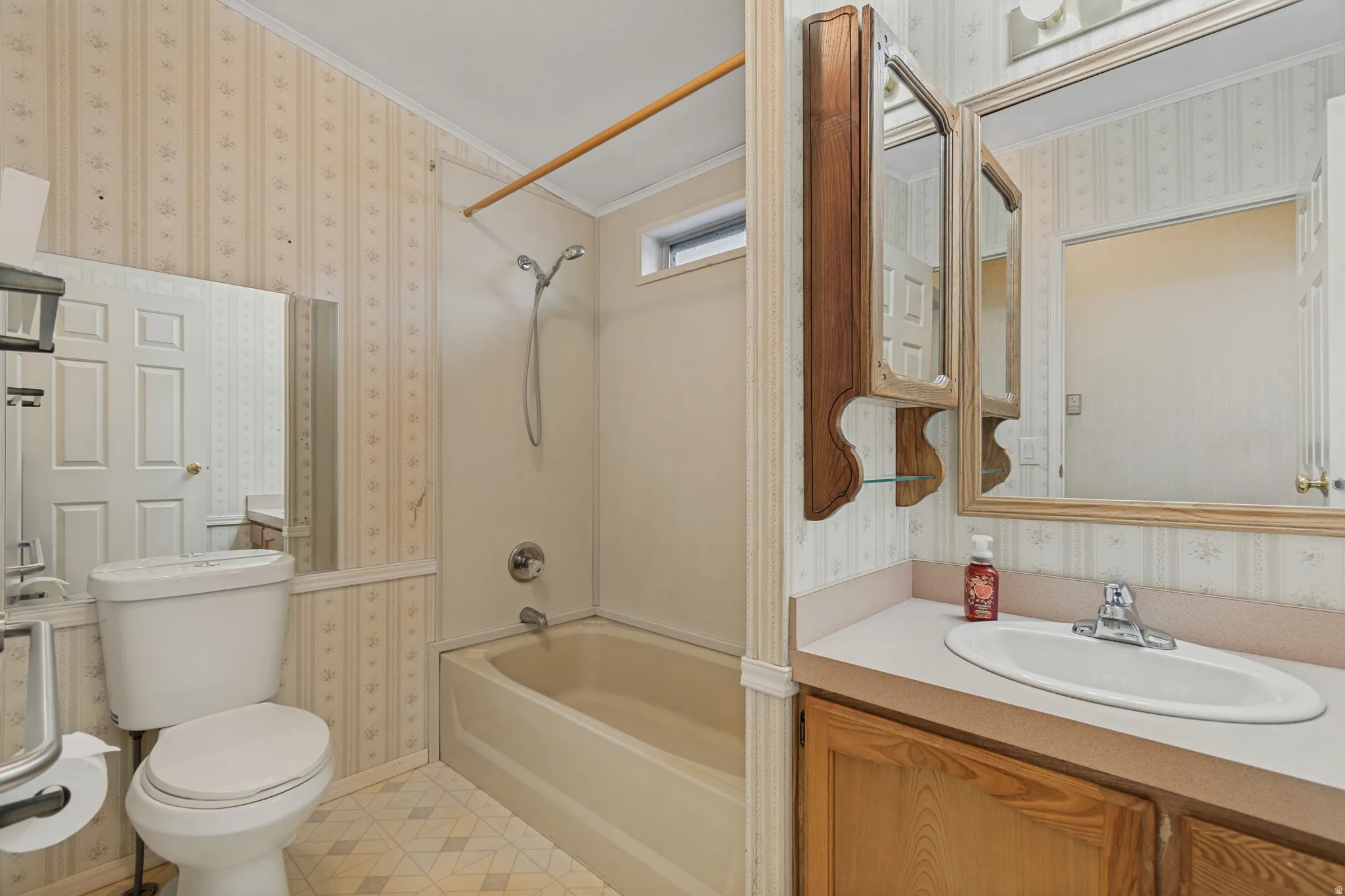 Second full bathroom, featuring a bathtub/shower combination, single vanity with integrated sink, wood-finish cabinetry, and a wall-mounted medicine cabinet