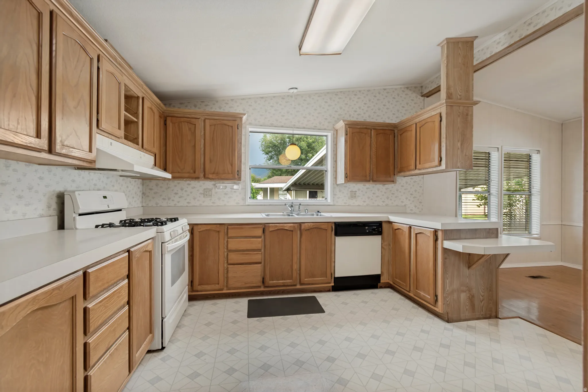 Large kitchen with plenty of cupboard space,  from laundry room area.