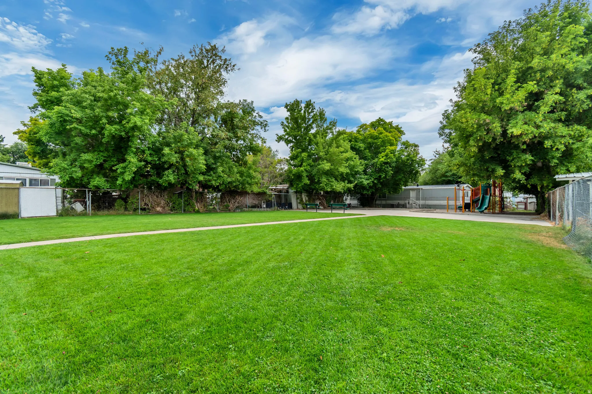 Park and playground with mature trees.