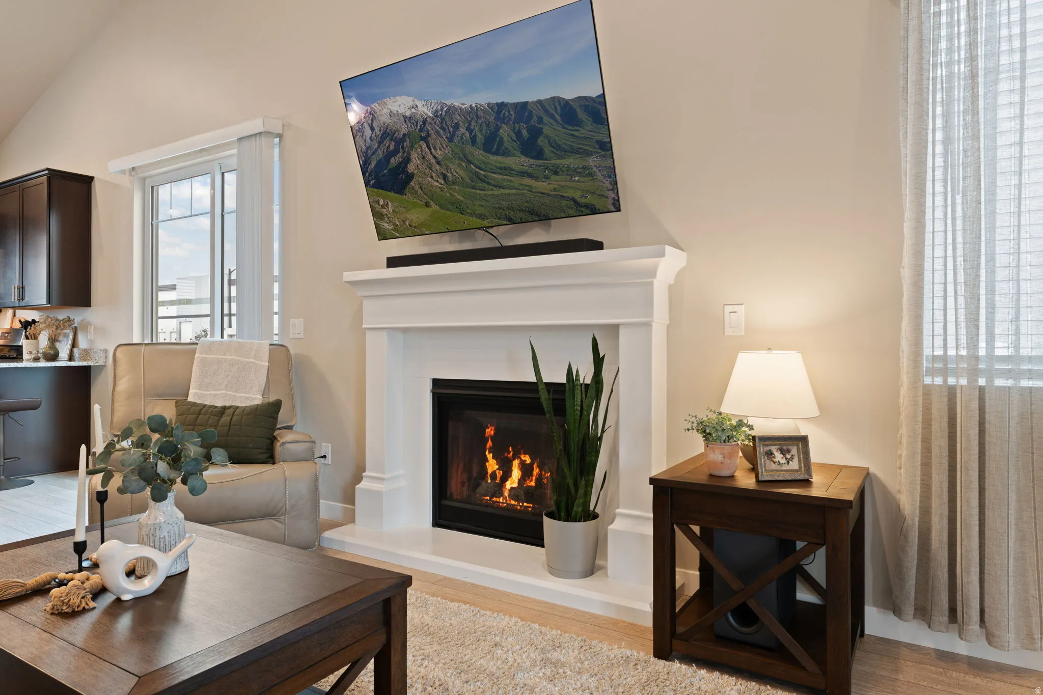 White mantel with integrated fireplace, wood-finish flooring, and recessed lighting