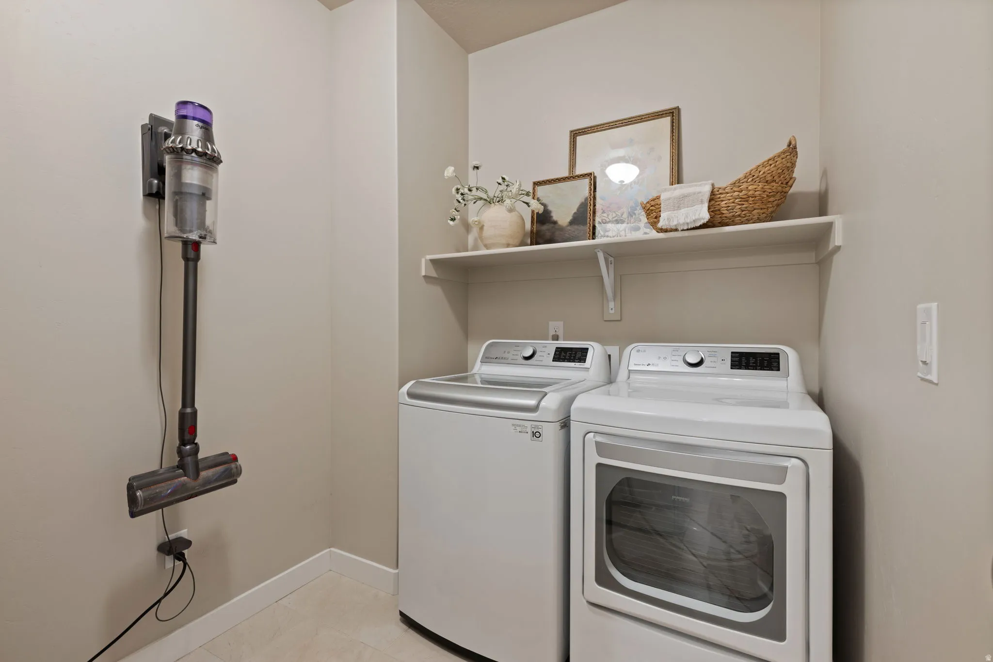 Dedicated laundry space featuring a white top-load washing machine and front-load dryer