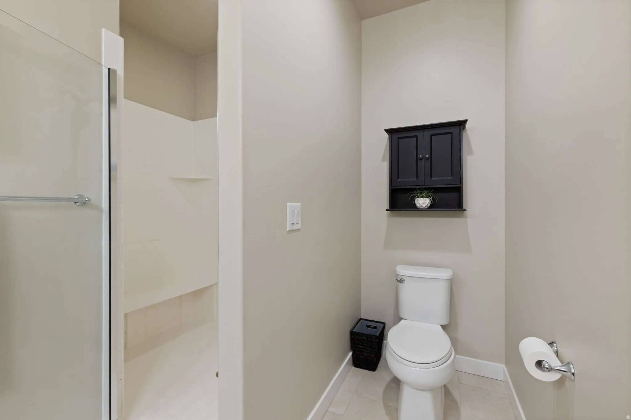 Walk-in shower with glass enclosure, integrated shelving, and a built-in bench