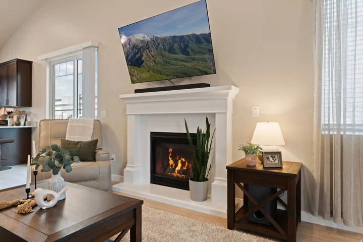 White mantel with integrated fireplace, wood-finish flooring, and recessed lighting