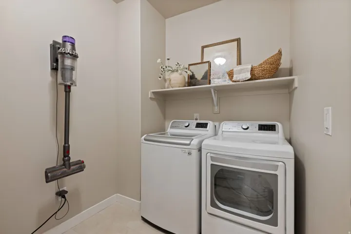 Dedicated laundry space featuring a white top-load washing machine and front-load dryer