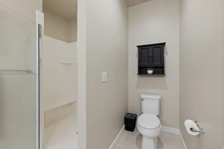 Walk-in shower with glass enclosure, integrated shelving, and a built-in bench