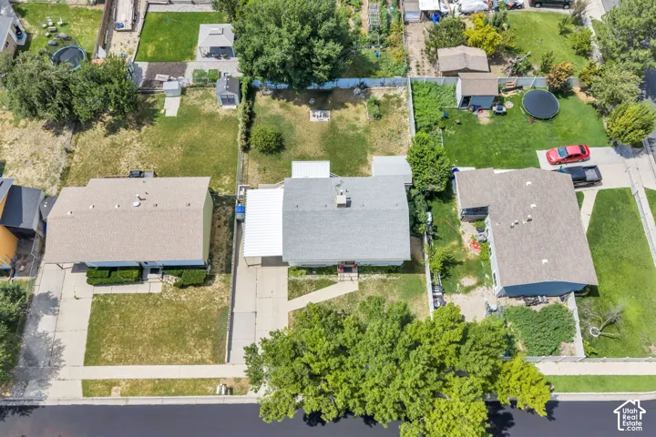 Gable roof structure with a covered carport, concrete driveway, and front lawn area
