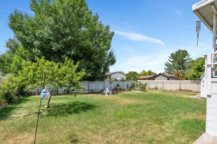 Expansive grass lawn with mature trees and perimeter fencing