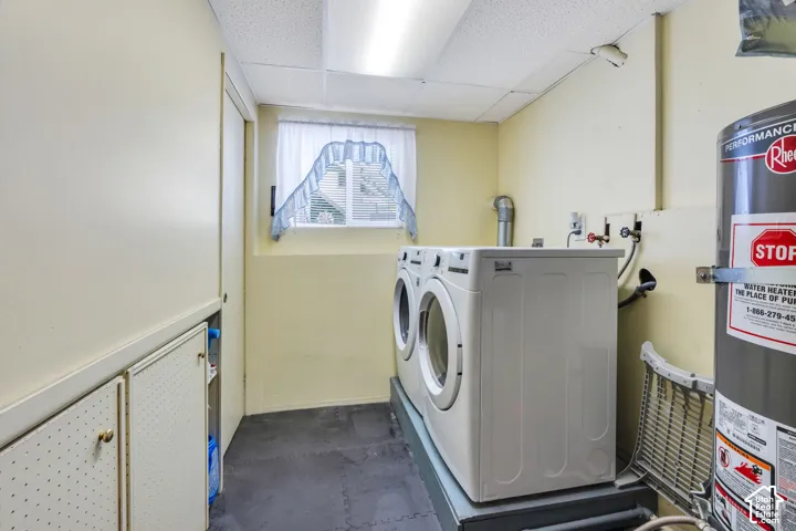 Utility room featuring built-in cabinetry, a window, and a water heater