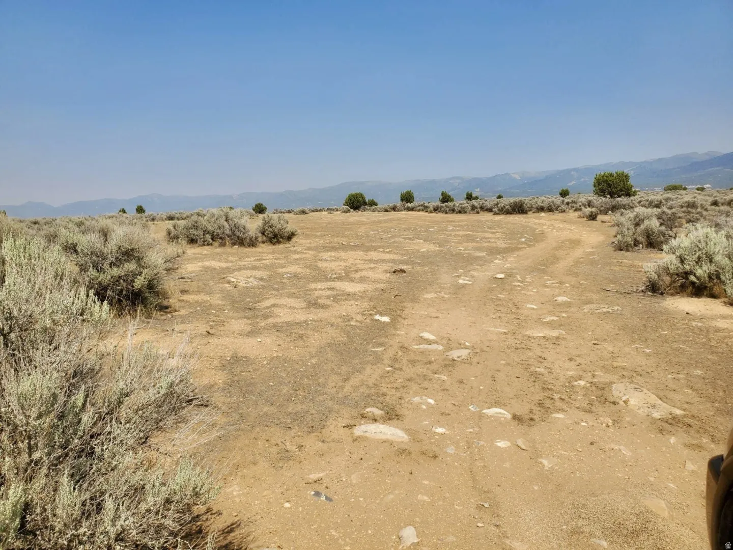 Expansive undeveloped land featuring natural desert vegetation and distant mountain ranges