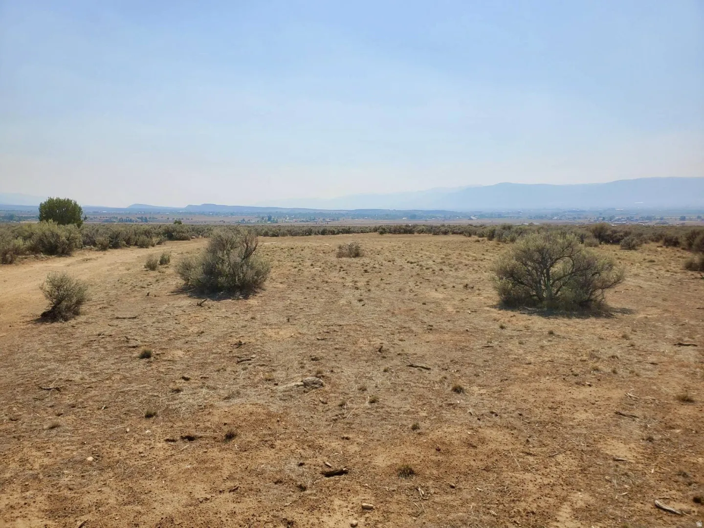 Expansive undeveloped land featuring natural terrain and distant mountains