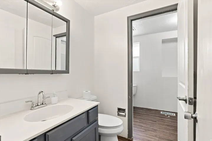 Vanity with integrated sink, chrome faucet, and dark-finish cabinetry
