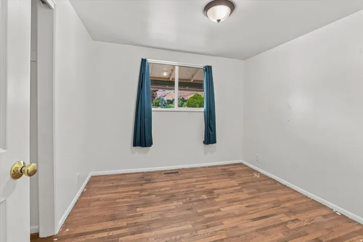 Wood-finish flooring throughout, featuring a window and overhead flush-mount lighting