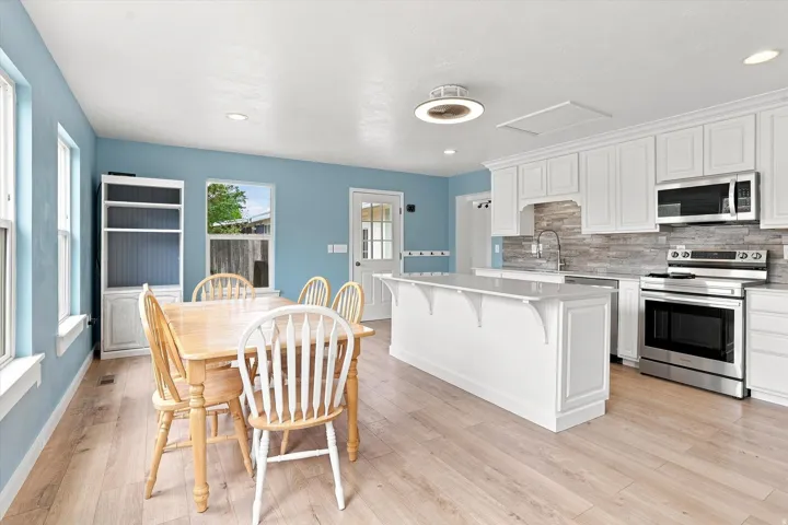 Open-concept kitchen and dining area with wood-finish flooring