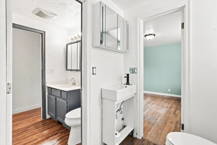 Dual vanity areas featuring white rectangular sinks and contrasting cabinetry