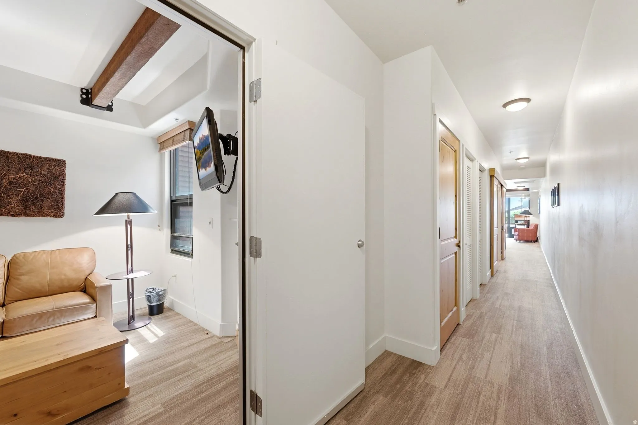 Hallway featuring wood-finish flooring, recessed lighting, and solid core doors