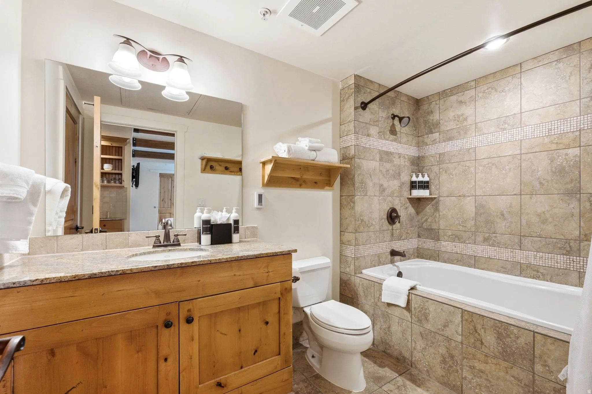 Wood-finish vanity with a light-colored countertop and integrated sink