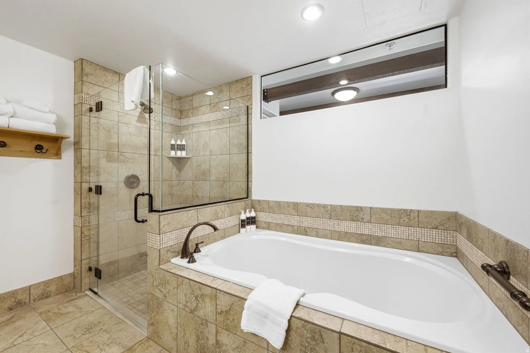 Tile-surrounded soaking tub with bronze-finish fixtures